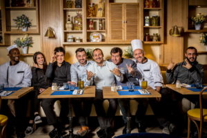 Image représentant une partie de l'équipe du Casa Leya. Ils se trouvent dans la salle du rez-de-chaussée, décorée avec des produits italiens. Nous retrouvons des chef de rang et des cuisiniers.